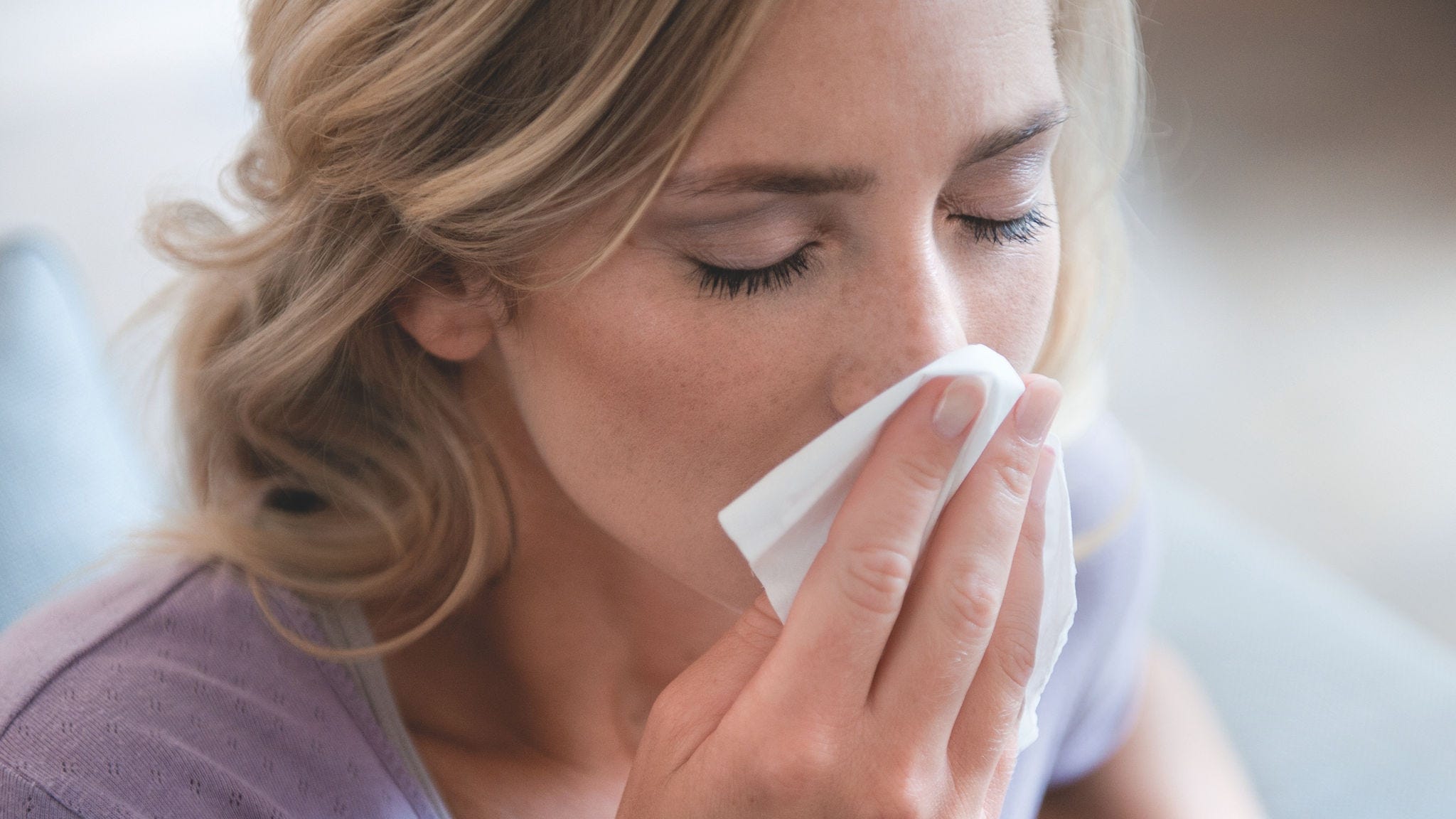Vrouw snuit haar neus vanwege hooikoorts