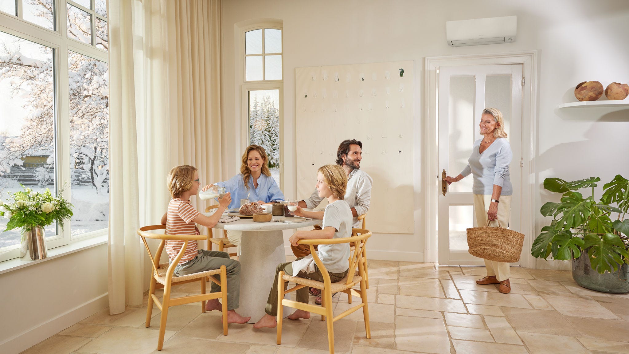 Gezin ontspant in de woonkamer en laat het comfort en de koeling zien die worden geboden door Daikins oplossingen voor wooncomfort