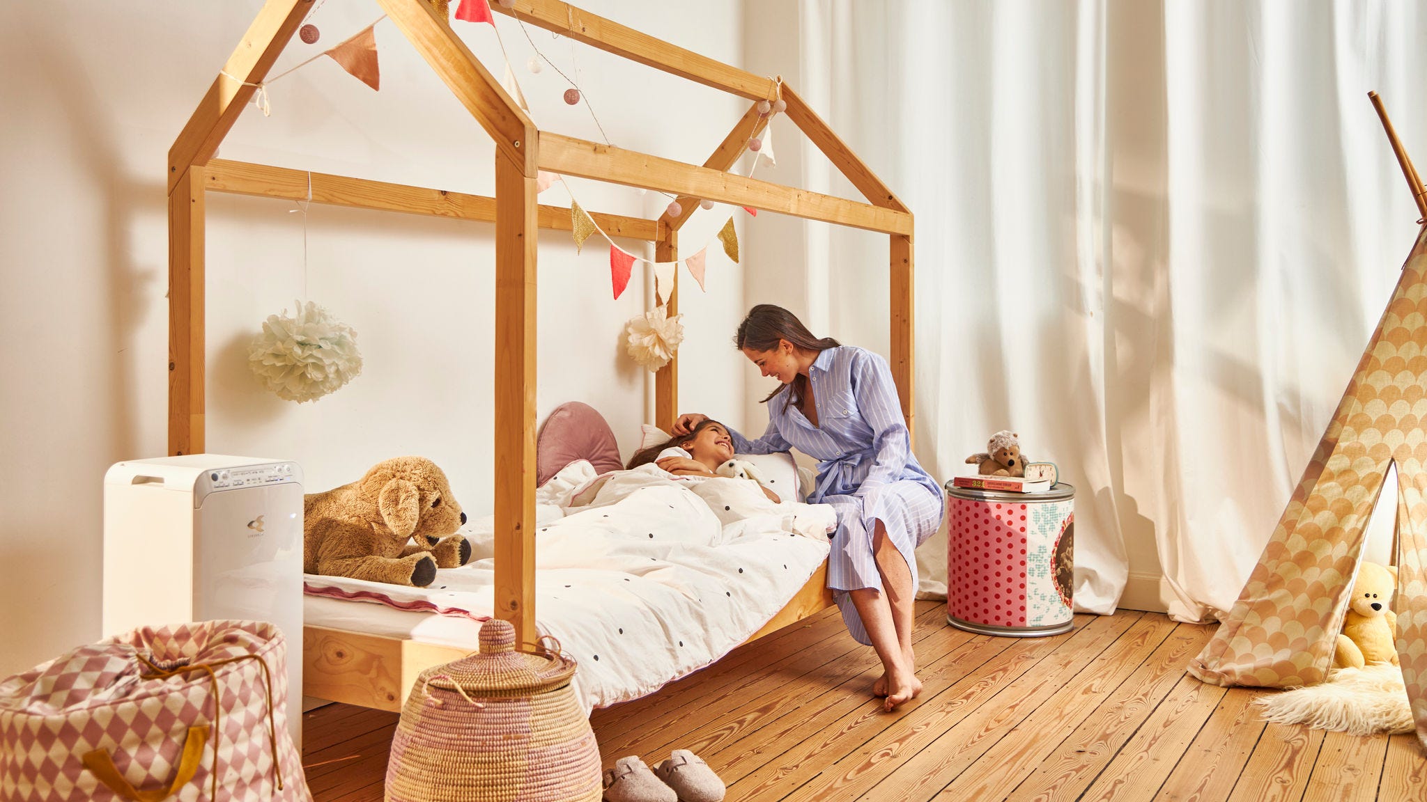 Moeder brengt kind naar bed, in hun gezonde huis dankzij de Daikin luchtreiniger, in de kinderkamer