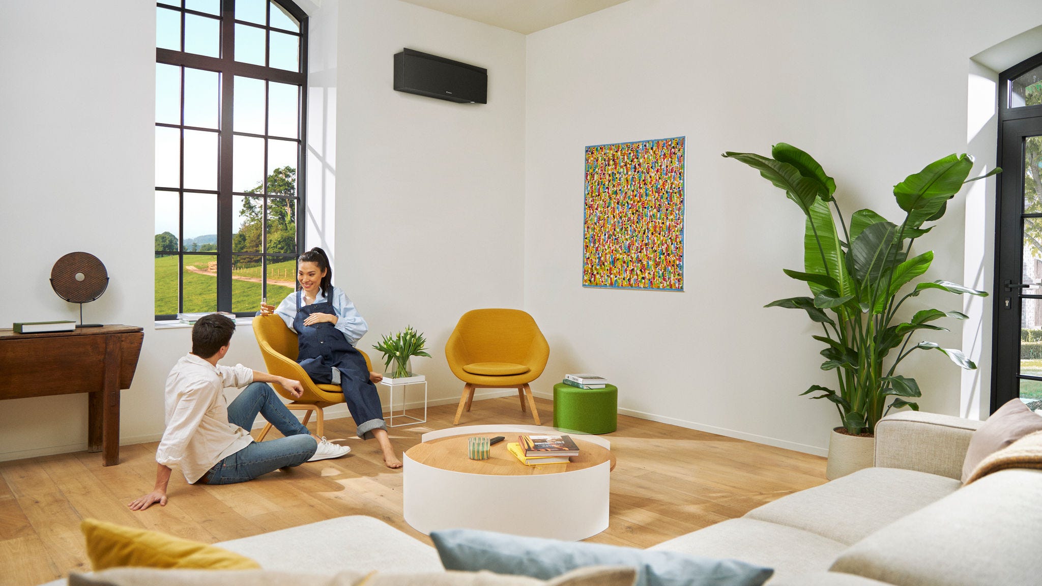 Zwanger echtpaar kletst gezellig terwijl de vrouw op een stoel zit