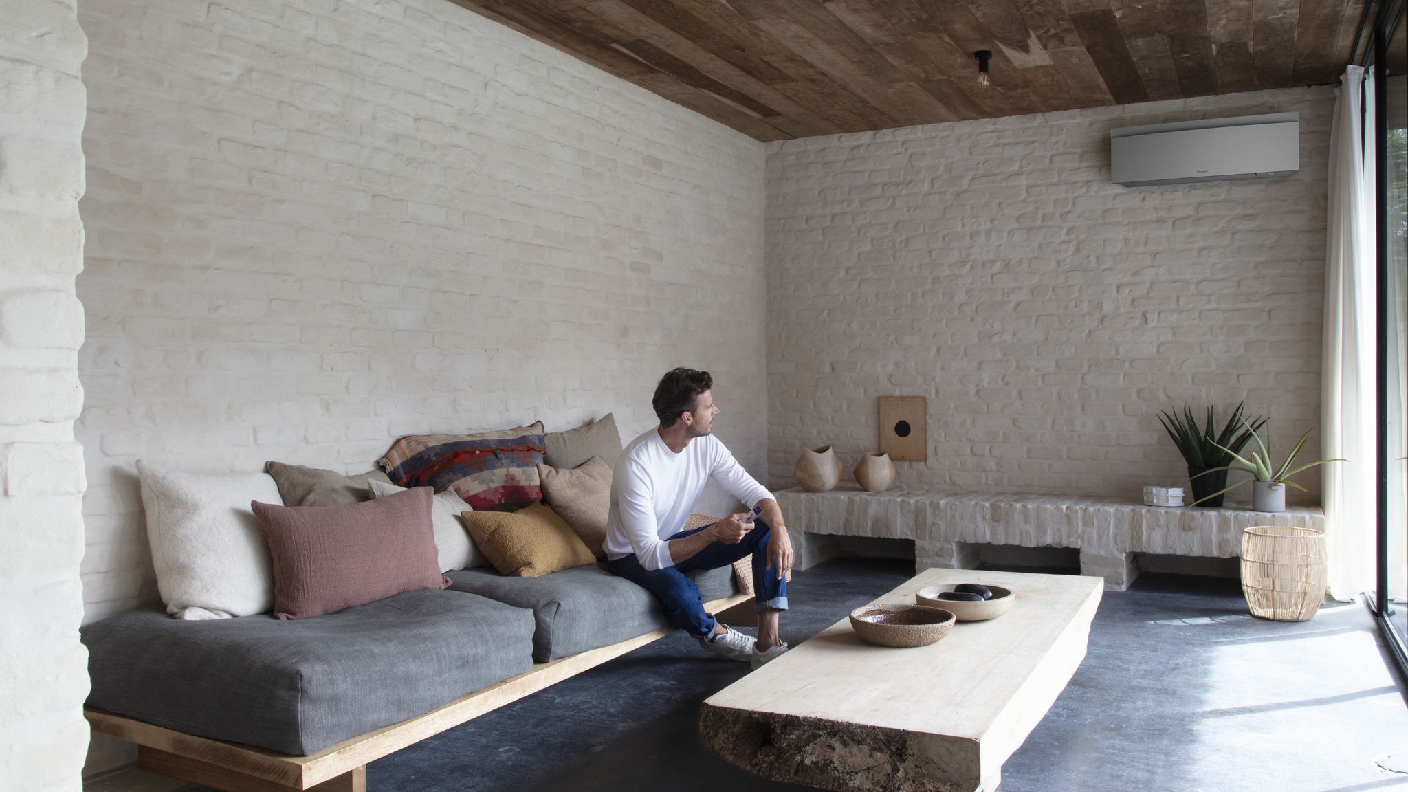 Man bedient zijn lucht/lucht warmtepomp in de woonkamer met een afstandsbediening