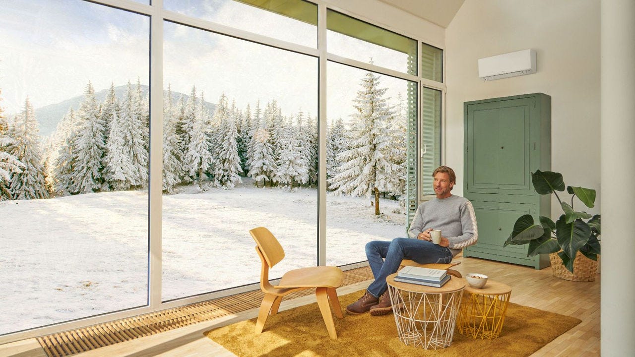 Man zit op de bank en geniet van verwarming met airconditioner