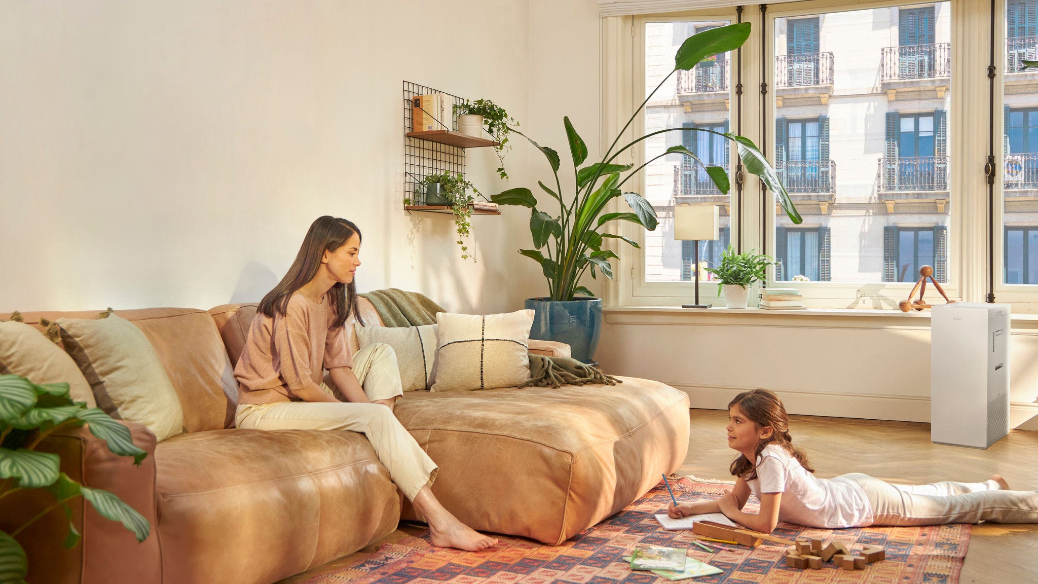 Moeder en kind thuis met een luchtreiniger die allergenen in huis vermindert en de luchtkwaliteit verbetert
