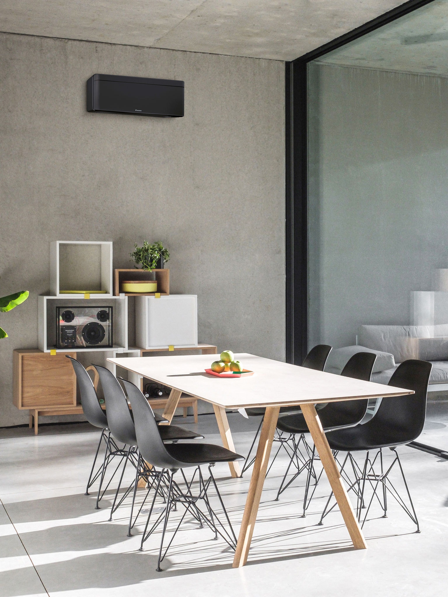 Eetkamer met een groot raam en een lucht/lucht warmtepomp aan de wand gemonteerd