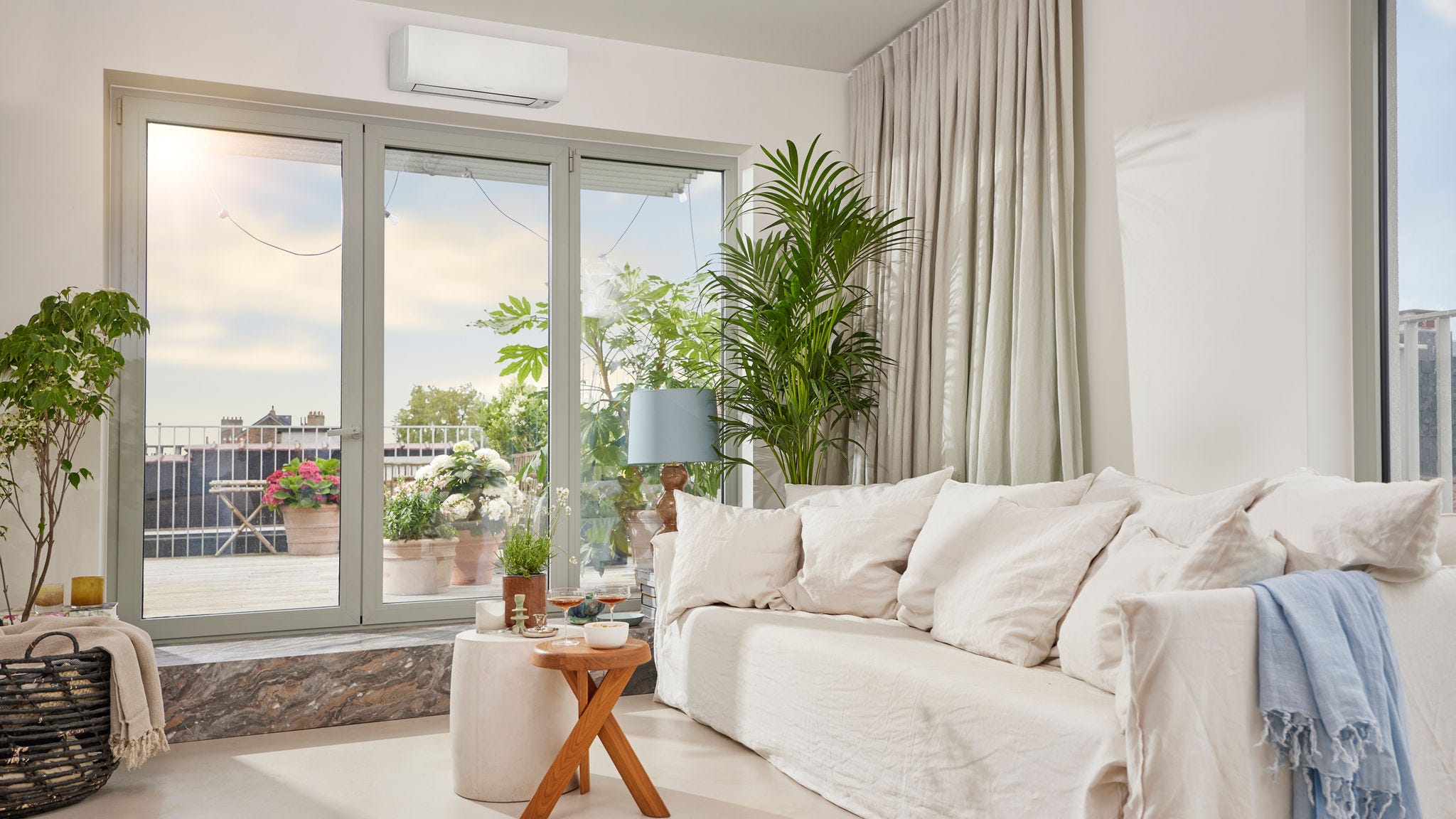 Een lichte, ruime kamer met een onopvallend wit wandmodel airco die zowel verwarmt als koelt