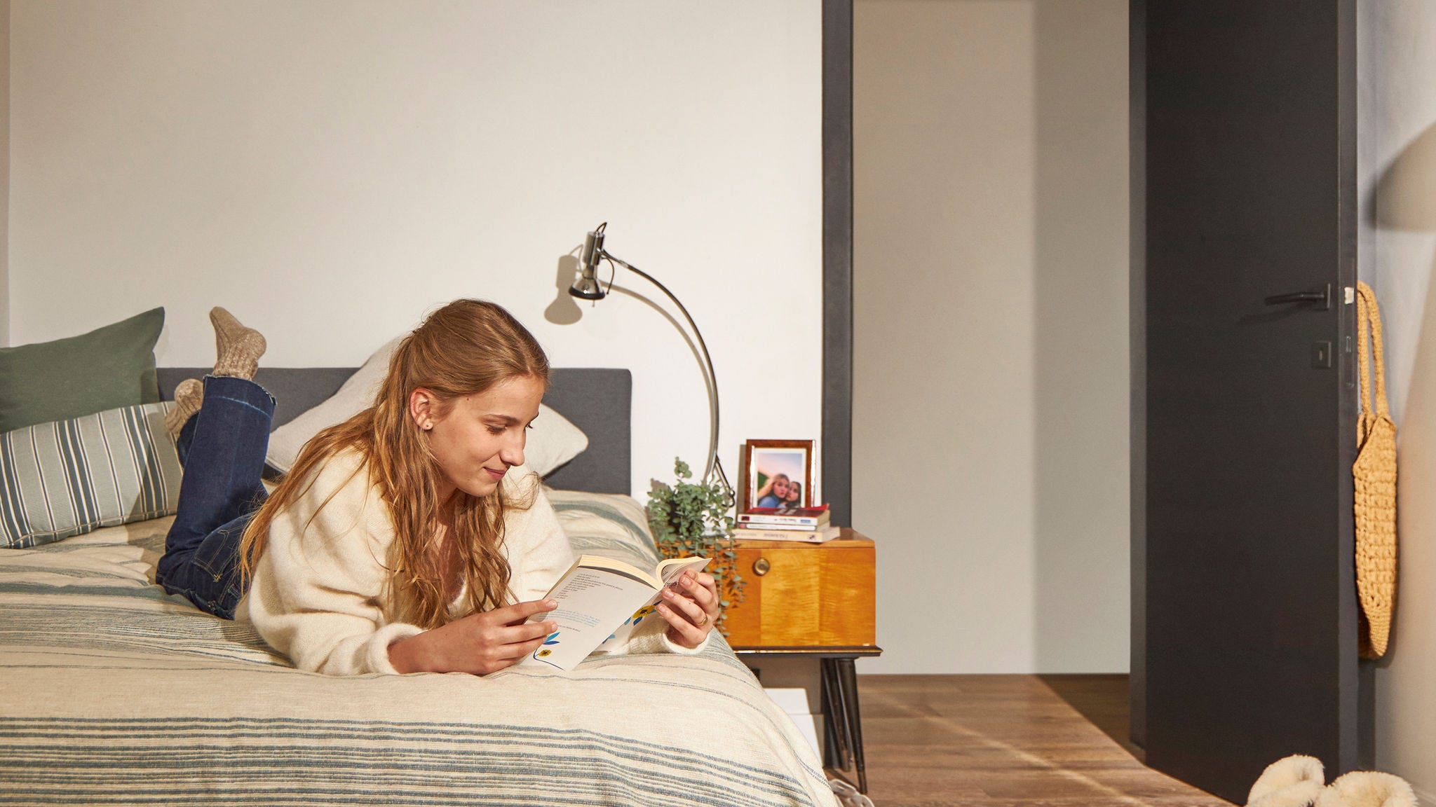 Vrouw ontspant op bed in een rustig huis met een fluisterstille warmtepomp
