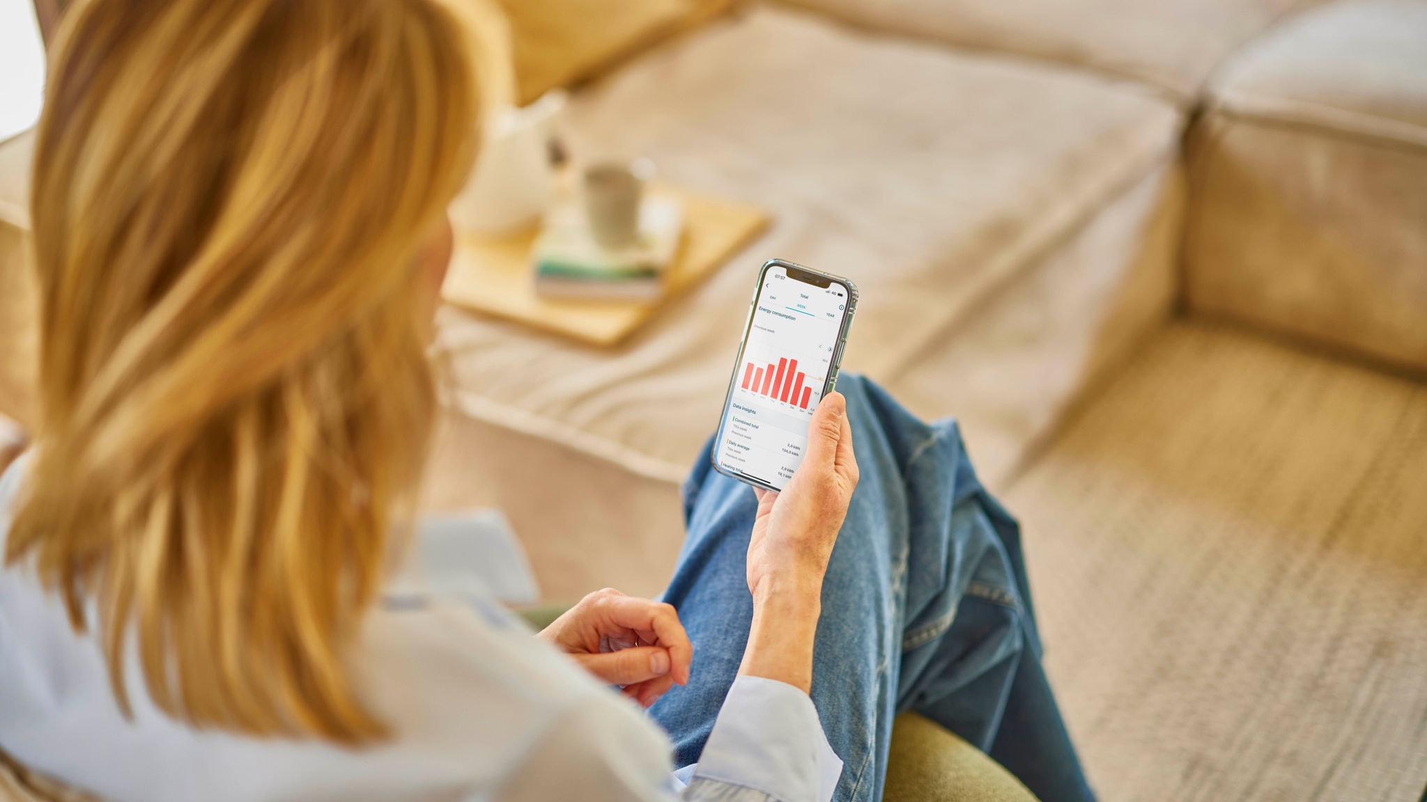 Vrouw bedient haar ventilatiesysteem met de Onecta-app