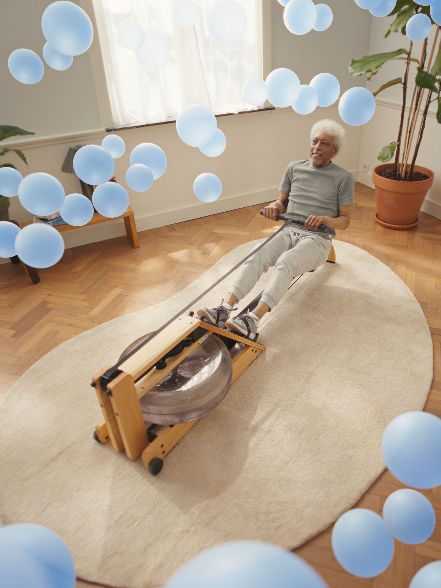 Een oudere man traint op een roeimachine in een perfect geklimatiseerde ruimte, dankzij de lucht/lucht warmtepomptechnologie