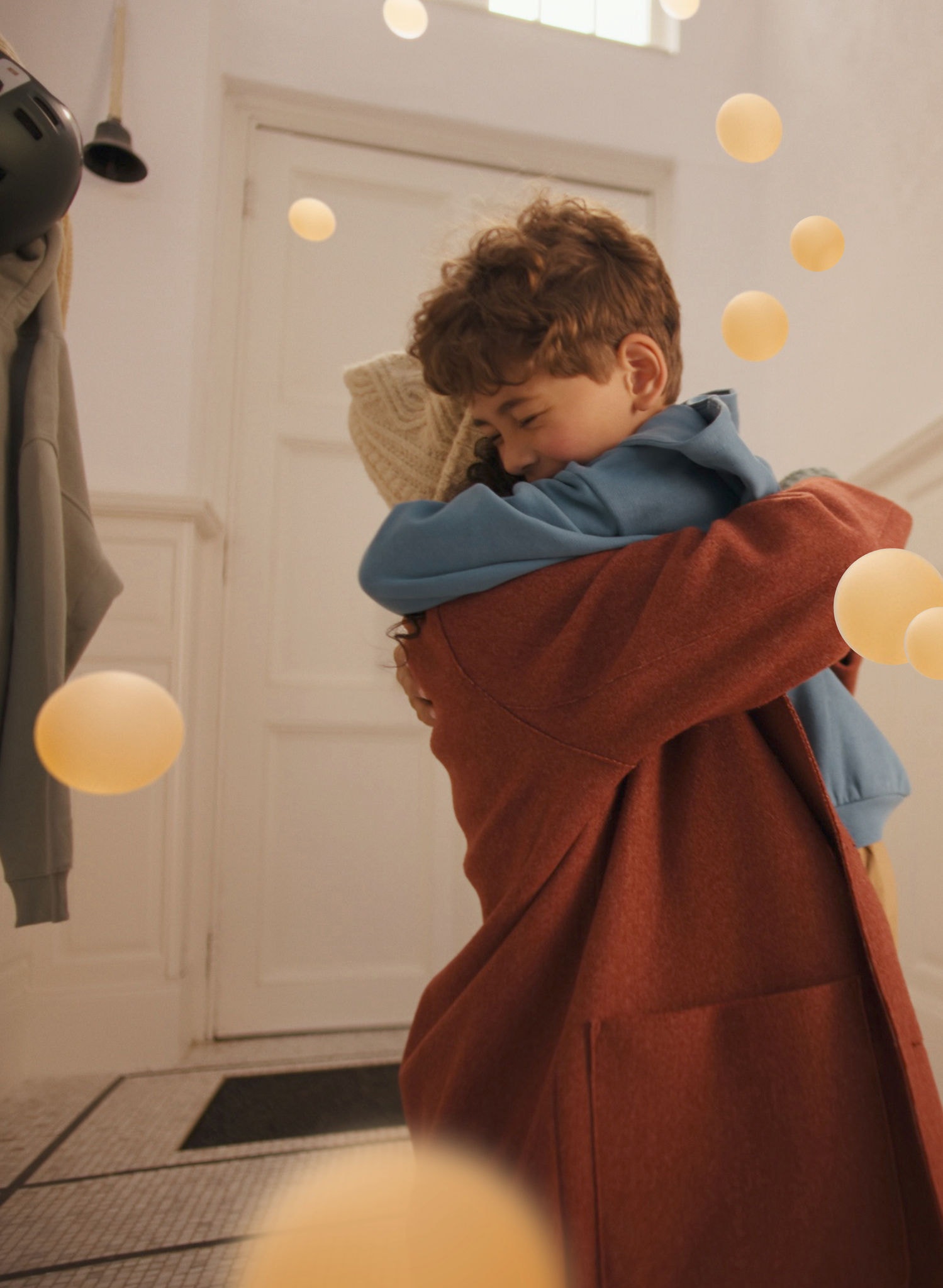Moeder en zoon delen een warme knuffel in een stijlvolle, serene woonkamer, genietend van fluisterstil comfort van een Daikin airconditioner