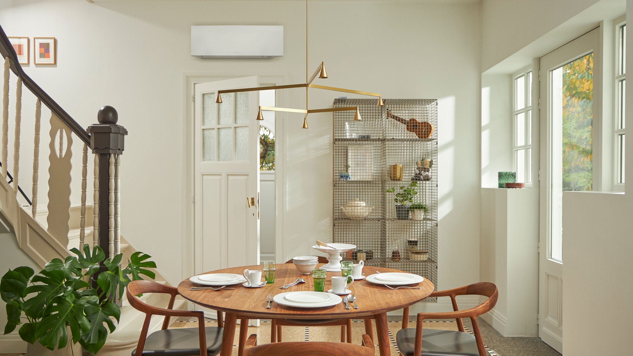 Kamer met groot raam, houten tafel en een zwart wandmodel aan de wand