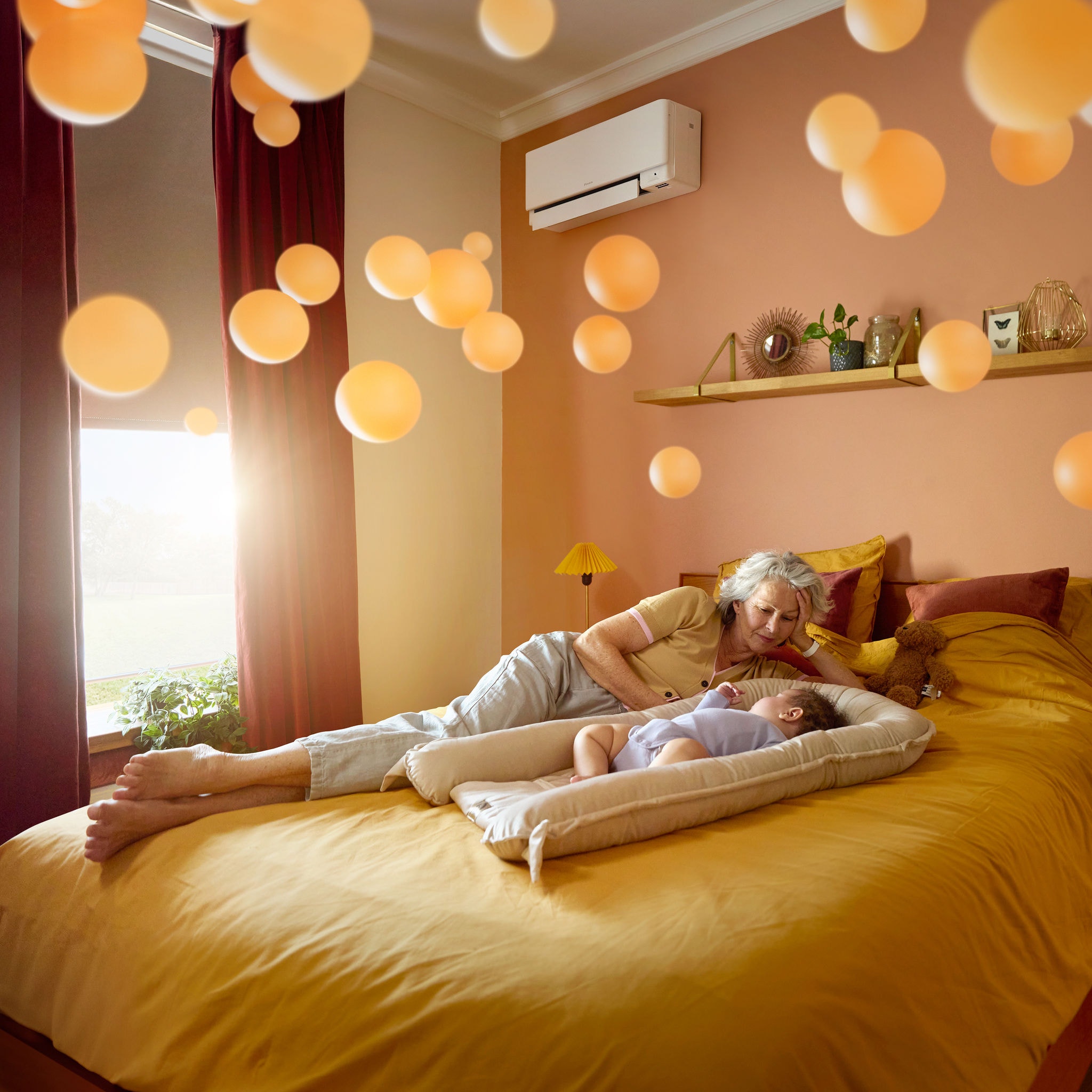 Een grootmoeder naast een vredig slapende baby in een stille, comfortabel verwarmde kamer, dankzij een fluisterstille airco
