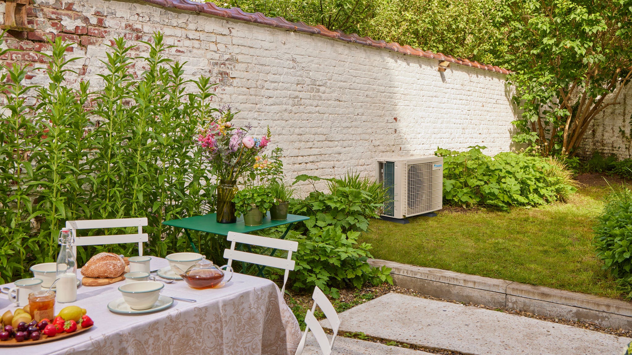 Ontbijt in tuin met een airconditioner met inverter die de woning koelt