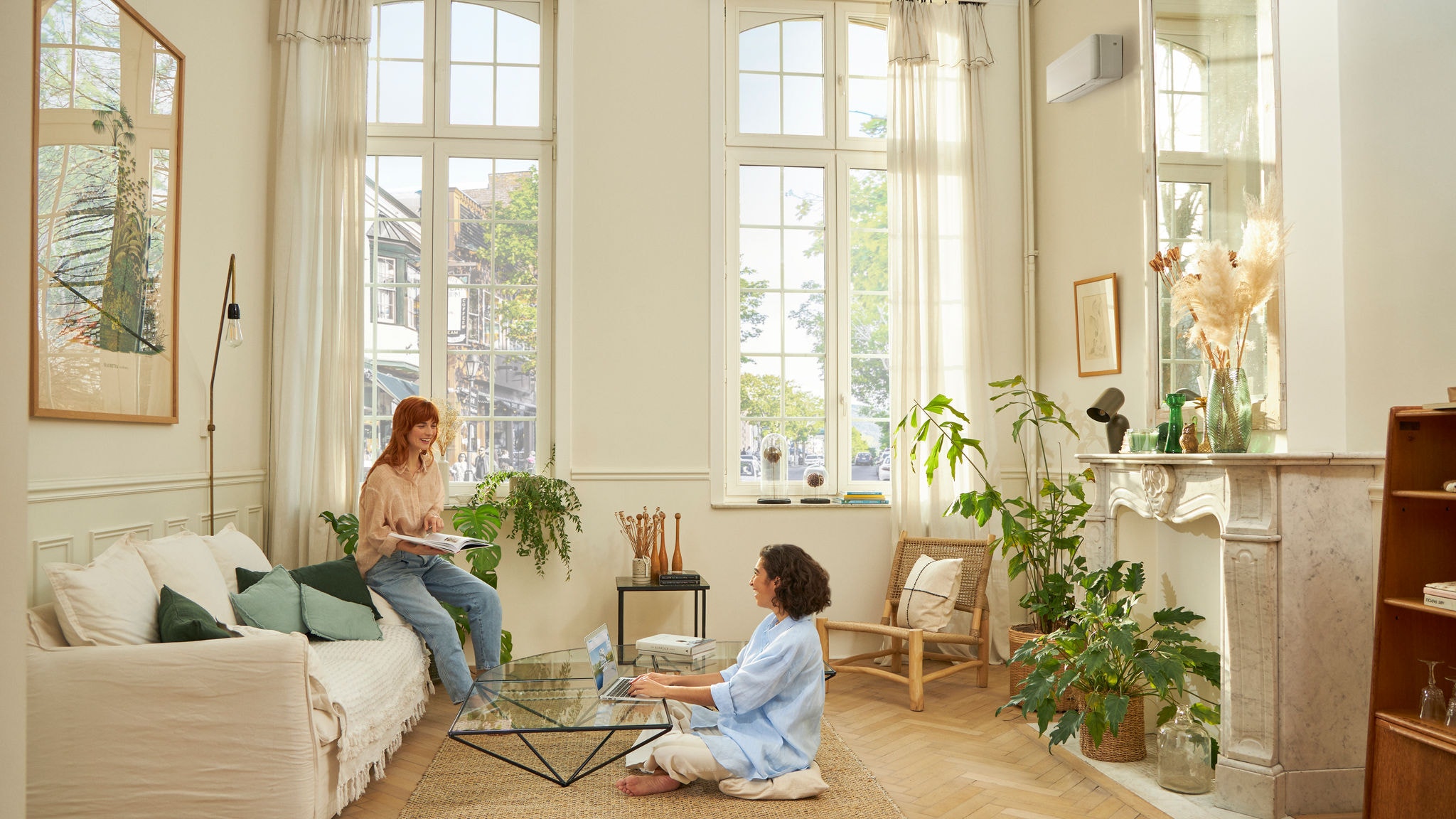 Vrouw zit comfortabel in de woonkamer dankzij lucht/lucht warmtepompen (airconditioning) van Daikin