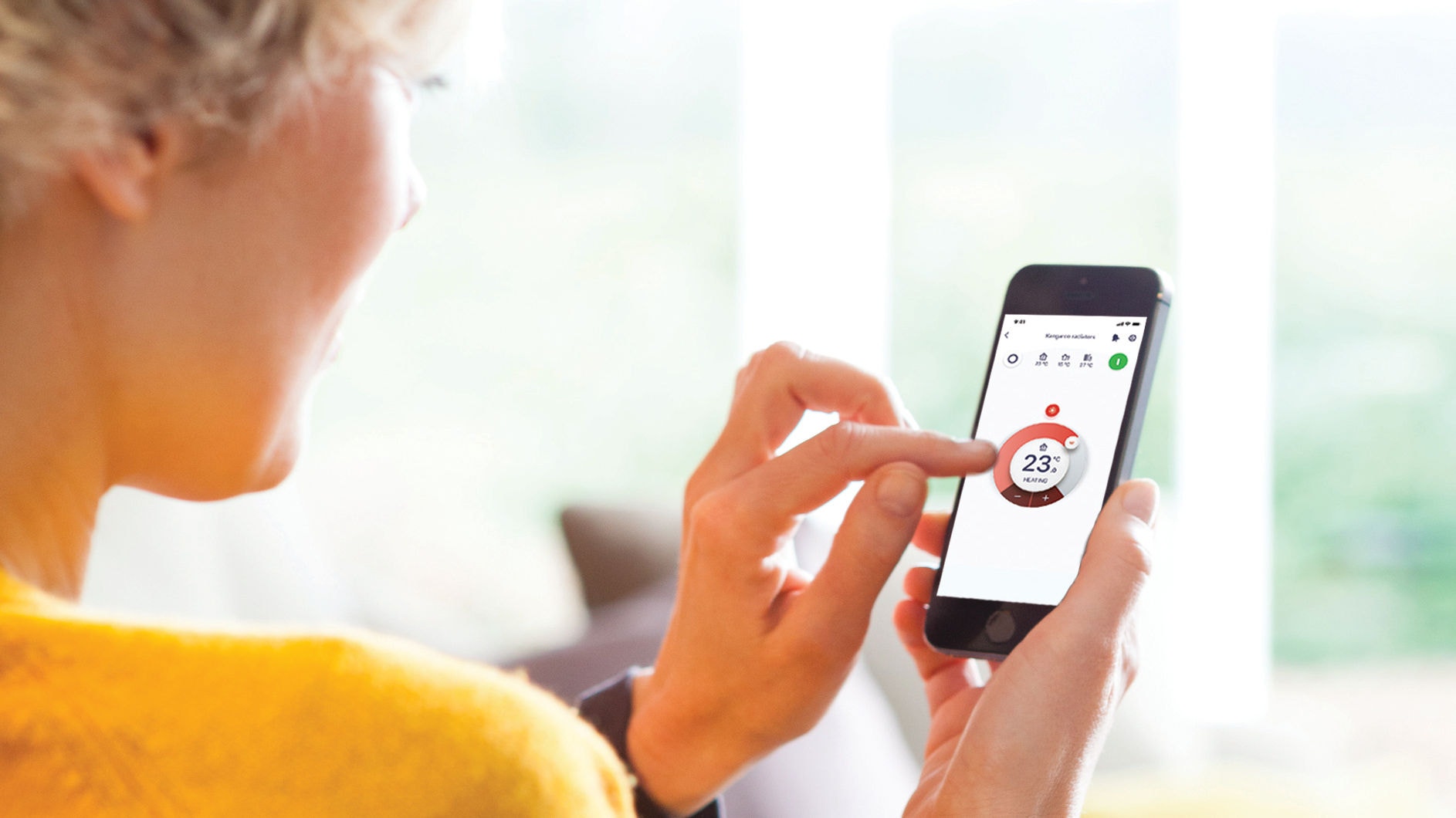Een vrouw gebruikt de Onecta app om de verwarming te controleren