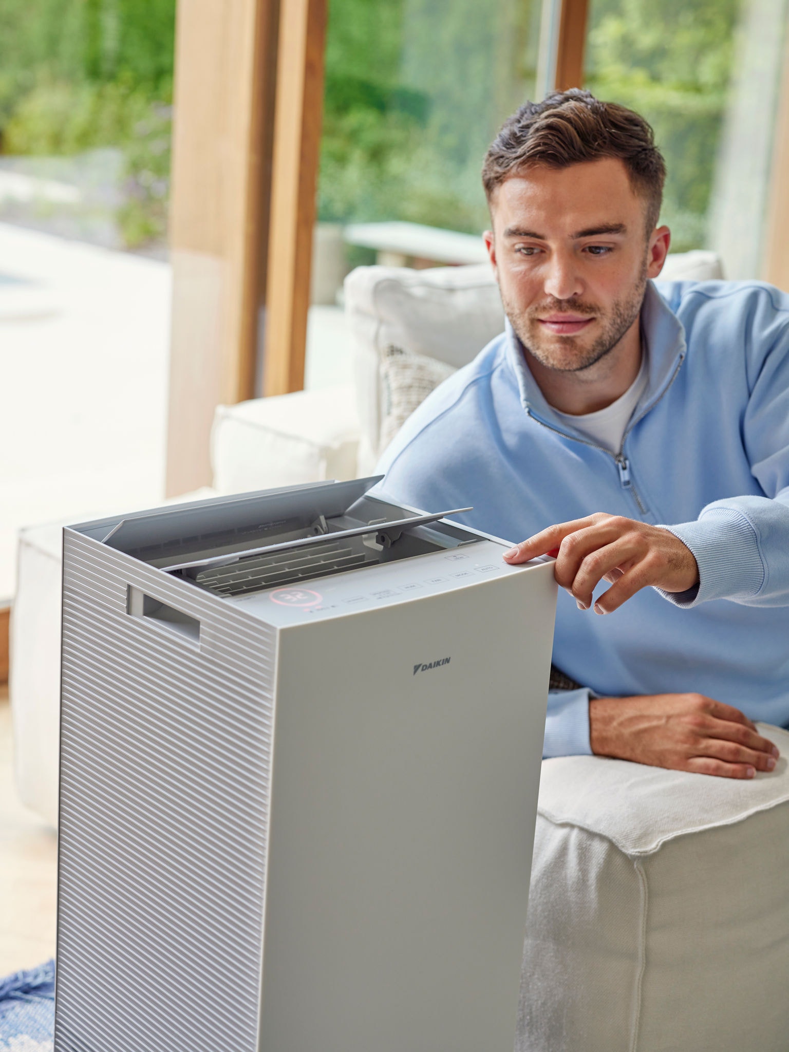 Man die zijn Daikin luchtreiniger in de woonkamer instelt om kattenallergenen te verminderen