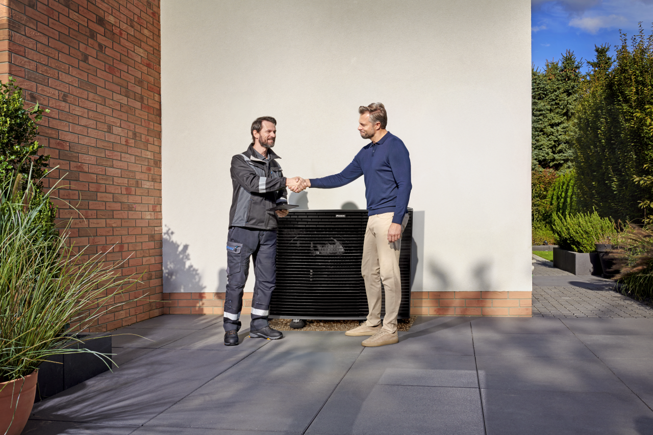 Installateur geeft klant een hand voor een Daikin Altherma-buitenunit